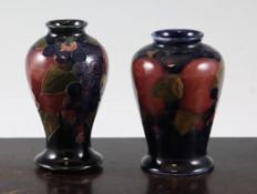 Two Moorcroft `Pomegranate` small vases; the former of baluster shape, c.1916, on dark ground,