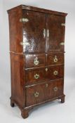An 18th century walnut cabinet on chest, with a pair of cupboard doors enclosing an interior with