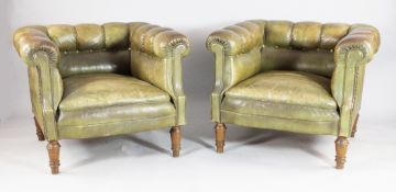 A pair of early 20th century French green leather button back armchairs, on turned oak supports