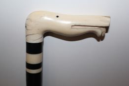 An Indian ebony and ivory walking cane, with stylised dog head handle, 35.25in. Starting Price: £