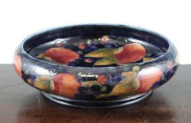 A Moorcroft `Pomegranate` shallow bowl, c.1930, on cobalt blue ground, impressed script marks, 10.