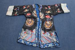 Two Chinese embroidered silk robes, early 20th century, each decorated with motifs on a black