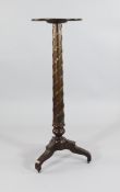 A 19th century mahogany torchere stand, the central column with gilt mounted bell husk decoration,