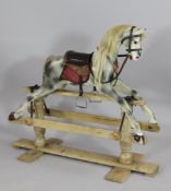 A small early 20th century dapple grey painted rocking horse, on pine frame, 3ft 3in. Starting