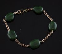 A 9ct gold and nephrite bracelet, set with five polished stones, 8in. Starting Price: £192