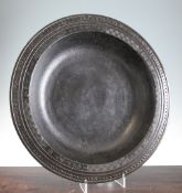 A large Chinese bronze dish, Yuan Dynasty, with a deep well to the centre, the barbed rim engraved