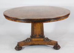 A mid 19th century oak circular breakfast table, with Gothic tracery, triangular column and platform