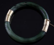 A gold mounted nephrite stiff bracelet. Starting Price: £80