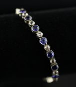 A gold and two colour synthetic sapphire line bracelet, set with thirty seven alternating blue and