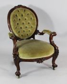A Victorian carved rosewood open armchair, with oval button back, scrolling arms and legs carved