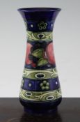 A Moorcroft `Pomegranate` slender baluster vase, c.1928, the banded borders on cobalt blue ground,