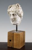 A Roman Hellenistic style marble head of Aphrodite, 1st/2nd century A.D., with top knot to her hair,
