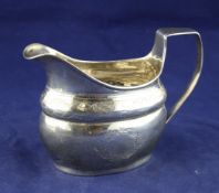 A George III Irish silver cream jug, of shaped oval form, with engraved foliate decoration,