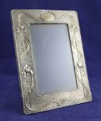 An Edwardian Art Nouveau silver mounted photograph frame, of rectangular form, embossed with