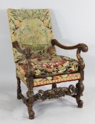 A Carolean style carved walnut open armchair, with tapestry back and seat, with scrolling arms and