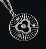 A 14ct white gold and diamond set wheel pendant, 1in, on an 18ct white gold fine link chain, gross