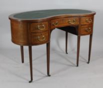 An Edwardian mahogany and satinwood crossbanded kidney shaped writing table, with five drawers, on