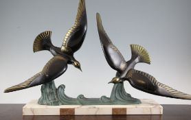 An Art Deco bronze group modelled as two seagulls on a crest of a wave, on white veined marble base,