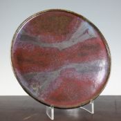 Attributed to David Martin (1937-). A flambe glazed stoneware circular dish, with raised lip,