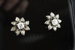 A pair of gold and diamond cluster set flowerhead earrings. Starting Price: £240