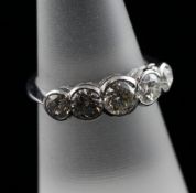 An 18ct white gold and graduated five stone half hoop diamond ring, the collet set stones weighing