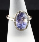 A gold, sapphire and diamond dress ring, the oval cut sapphire weighing approximately 7.60ct and