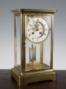 An early 20th century brass four glass mantel clock, with visible escapement and mercury pendulum,