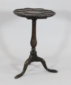 An 18th century carved oak tripod supper table, the top carved with nine circular divisions and