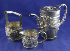 An early 20th century Japanese silver three piece coffee set, of cylindrical form, with applied