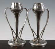 A pair of Liberty Tudric pewter tulip vases, pattern 029, with sinuous handles and circular bases,