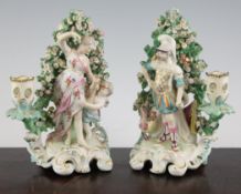 A pair of Derby candlestick figures, c.1770, each modelled as classical gods standing before bocage,