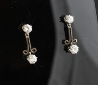 A pair of 18ct gold and diamond set drop earrings, with scroll stems. Starting Price: £240