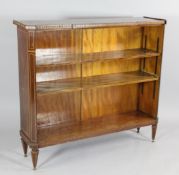 A mahogany boxwood and ebony inlaid open bookcase, with canted corners, on tapering legs and brass