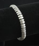 An 18ct white gold and diamond articulated line bracelet, each shaped oval link set with six