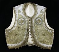 A child`s Ottoman waistcoat, with gold braid tugra and turquoise coloured bead decoration, 15in. W.