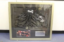 Mike Tyson. A pair of boxing shorts, signed 21st April 2012, framed with photograph and caption