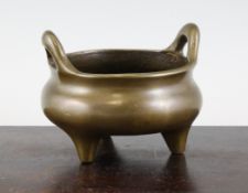 A Chinese bronze tripod censer, 18th / 19th century, of compressed globular form, with a pair of