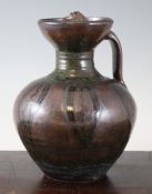 Ladi Kwali (1925-1984). An Abuja stoneware water jug, with layered green ash over dark brown glazes,