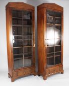 A pair of slender mahogany bookcases, each with a single door with eight glazed panels over three