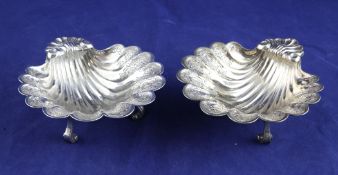 A pair of George V silver butter shells, with chased foliate decoration and shell thumbpieces, on