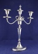 A George V silver two branch three light candelabrum, with scroll arms, on tapering panelled stem