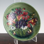 A Moorcroft `Spring Flowers` shallow bowl, c.1960, on cobalt blue ground, inscribed `W.M` mark,