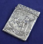 An Edwardian repousse silver card case, of rectangular form, decorated with figures in a garden with