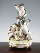 A Continental porcelain group of three cherubs, 20th century, each holding flowers and modelled