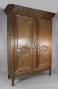A 19th century French carved oak armoire, with two doors decorated with baskets of flowers, W.5ft