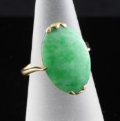 A 20th century gold and jadeite ring, set with oval stone, size N. Starting Price: £120