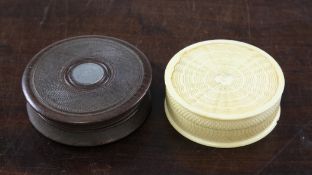 A 19th century engine turned circular ivory snuff box, together with a similar engine turned oak