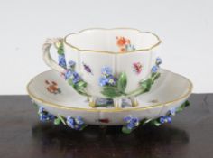 A Meissen flower encrusted tea cup and saucer, late 19th century, typically painted with flowers and