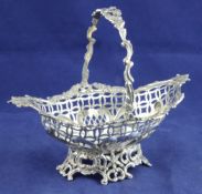 A late Victorian pierced silver sweetmeat basket, by William Comyns, decorated with foliate scrolls,