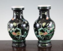 A pair of Chinese famille noire baluster vases, Kangxi six character mark, c.1920, each painted in